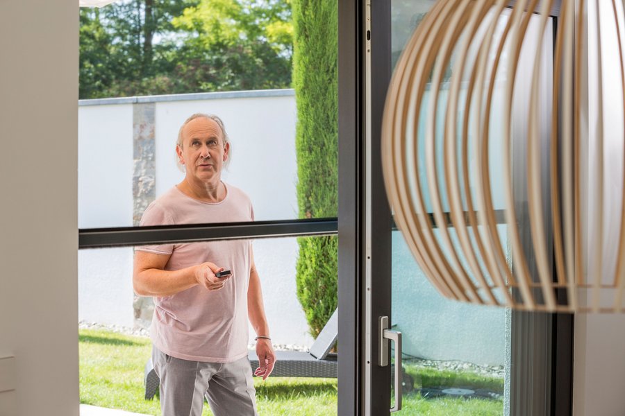 Hört auf einen Knopfdruck: Elektrische Insektenschutzrollos lassen sich per Fernbedienung betätigen oder in Smarthome-Systeme integrieren. Foto: djd/Neher Systeme