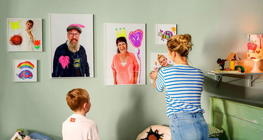 Echte Unikate als Wandschmuck: Familienfotos, die von den Kids kunterbunt verschönert wurden, werten jeden Raum auf. Foto: djd/CEWE